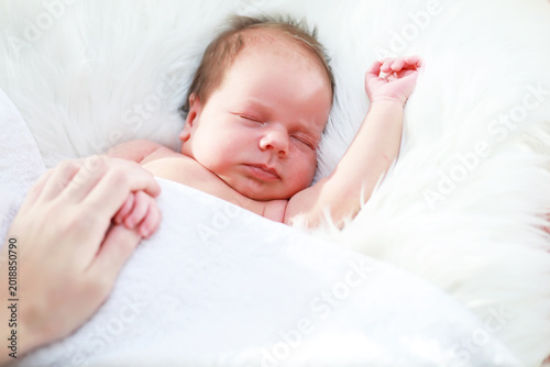 Obraz na płótnie A newborn baby lies in her mother's arms