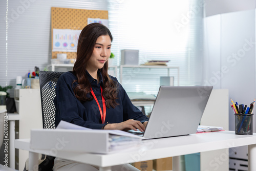 Businesswoman office laptop desk computer typing paperwork workspace employee