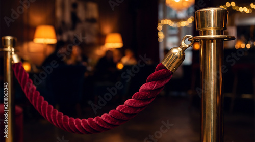 Elegant Red Velvet Rope and Brass Stanchion in a Moody VIP Lounge Entrance