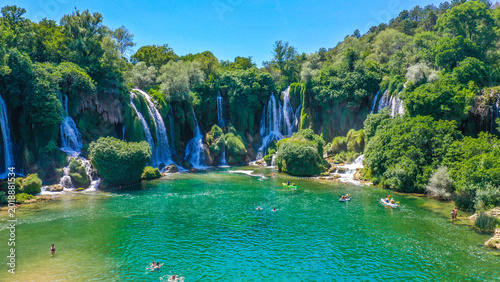 Foto A river flows amidst stones and dampness; perfect nature coexists, Natural waterfalls amidst green, tree-filled mountains