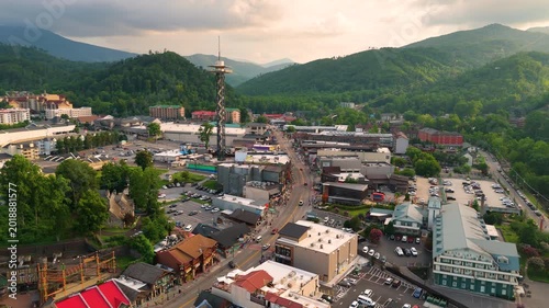 Aerial panorama of Gatlinburg, Tennessee with bustling main street filled with shops and attractions, observation tower and Smoky Mountains National Park nearby.