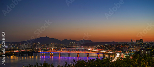 Fotografía Seoul Cityscape with the Brightly Illuminated Banpo Bridge and Han River Reflect