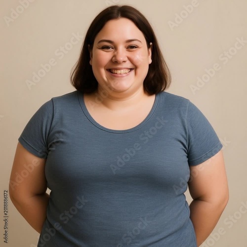 Plus-size woman smiling with hands behind her back indoors  