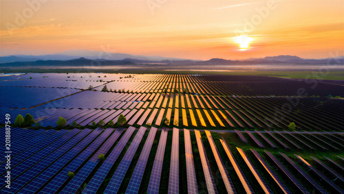 Solar Field at Dawn: An expansive solar panel array glistens under the soft hues of dawn, harnessing the sun's energy for a sustainable future.