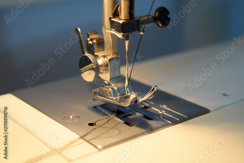 Foto Sewing machine presser foot and needle assembly with thread on a metal plate