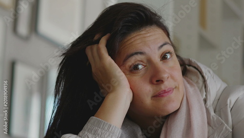 Photos Woman resting head on hand with gentle thoughtful expression as she gazes upward