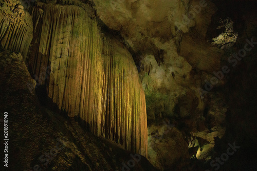 Bild auf Leinwand Dramatic limestone cave interior featuring impressive stalactites and stalagmites formed over thousands of years