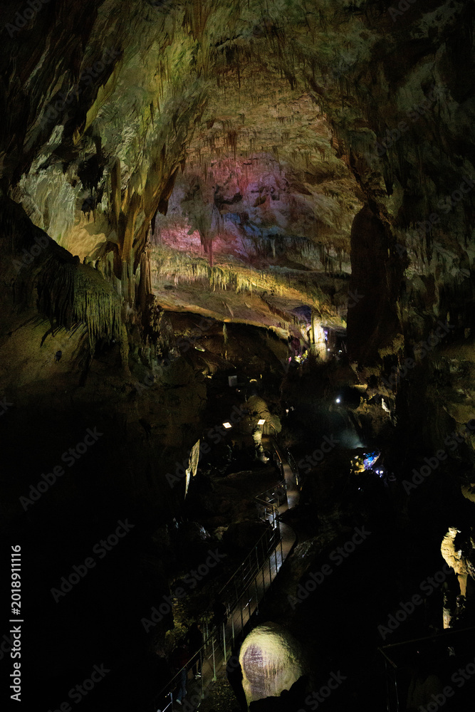 Obraz premium Dramatic limestone cave interior featuring impressive stalactites and stalagmites formed over thousands of years. A fascinating underground landscape showcasing geological heritage, natural wonders, a