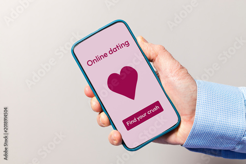 Hand holding smartphone with online dating app display