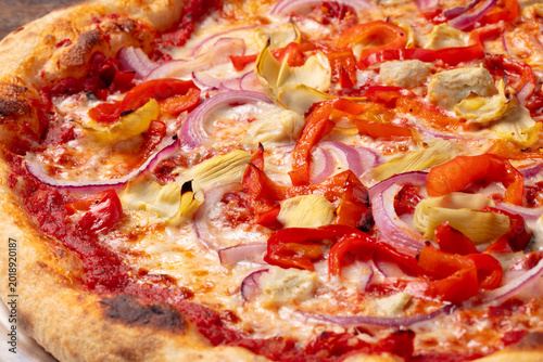 Close up of vegetarian pizza with red peppers and red onion, melted cheese and crispy artisan crust, detailed italian pizza texture photography