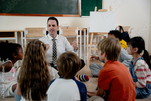 education. back to school. Elementary teacher leading group discussion with diverse students sitting in classroom circle. Interactive learning, communication skills, teamwork and child development