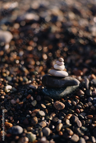 Canvas Print Stacked stones form a quiet balance on a pebble beach with soft light, a zen ins