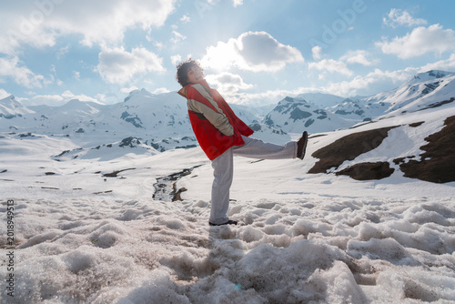 Foto Mujer en la nieve rodeada de montañas durante una aventura invernal al aire libre