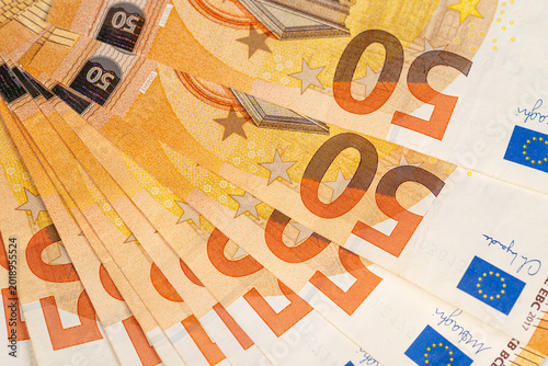 Slika na platnu Stacked euro banknotes near retail register visual, layered fifty notes imply po
