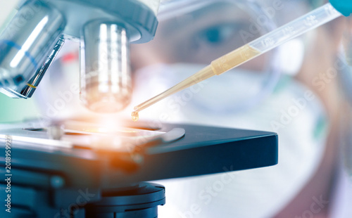 Close up of Scientist hands with microscope in medical research lab or science laboratory.