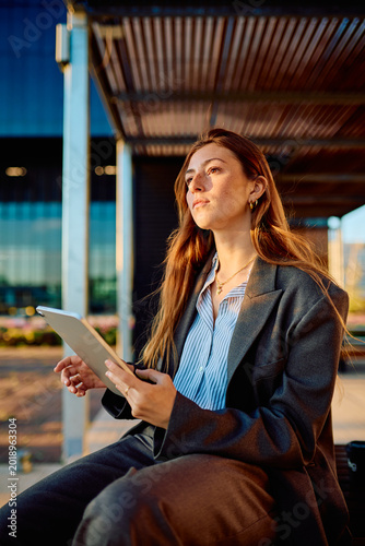 Quadro su tela Young business professional woman holding a digital tablet and looking with a vi