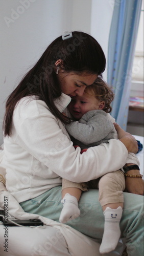 Принти на полотні Mother holding crying toddler while showing exhaustion patience and care as chil