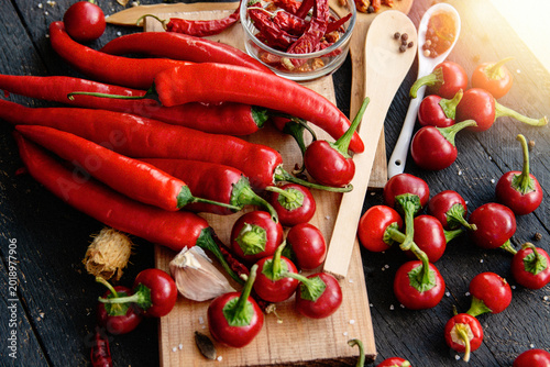 Photos Vibrant red chili peppers on rustic wooden board with spices and garlic