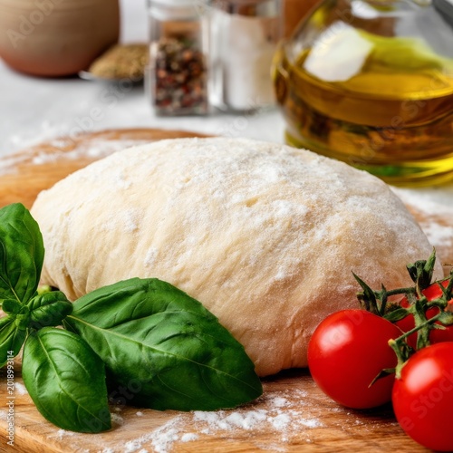 Dough Sits on a Wooden Board With Tomatoes and Fresh Basil in a Kitchen Setti...