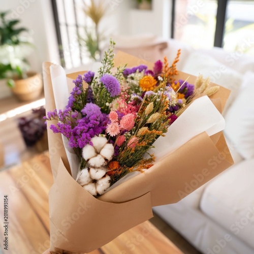 Colorful Bouquet of Dried Flowers Held in Hand Near a Bright Living Room