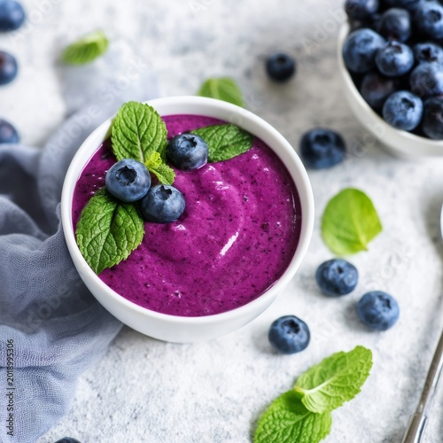 Blueberry Yogurt With Mint Leaves on a White Surface in a Bright Setting