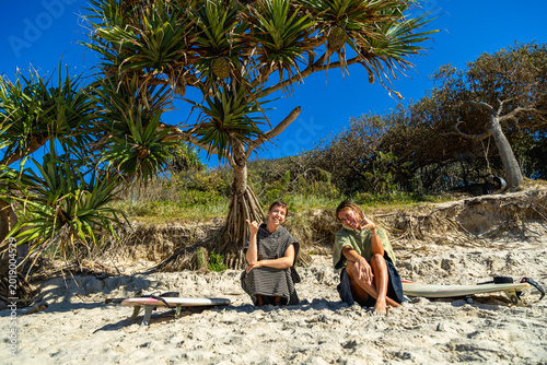 Tablou pe pânză Two women enjoying beach day after surfing in australia