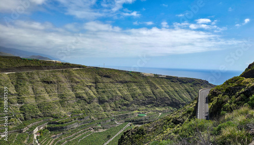 Cuadro en lienzo Scenic view of terraced green hillsides leading down to the ocean, with a windin