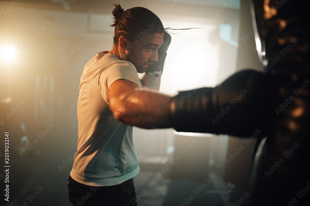 Fototapeta premium Male athlete boxing in gym for strength training, dedicating to fitness and healthy lifestyle