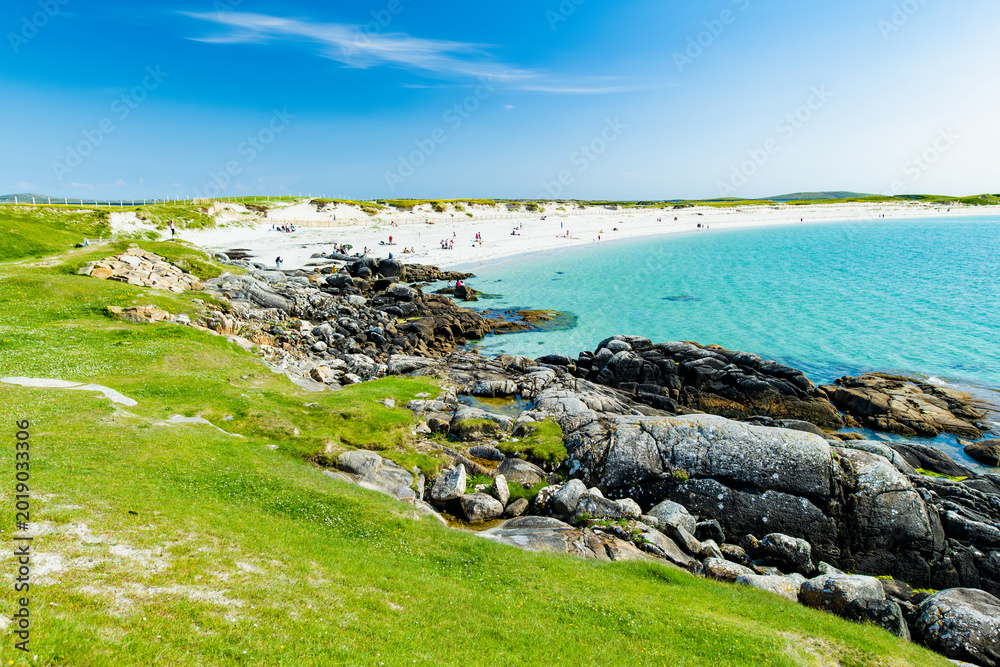 Naklejka premium Rocky shoreline and turquoise water at Dogs Bay near Roundstone, Connemara, County Galway. Scenic white sand beach on the Wild Atlantic Way beside Gurteen Bay, Ireland