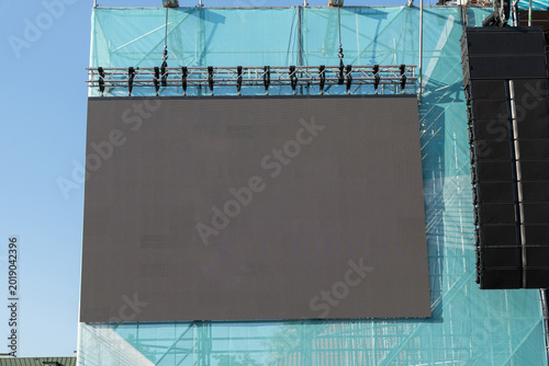 Large blank outdoor LED video screen mounted on concert stage metal truss
