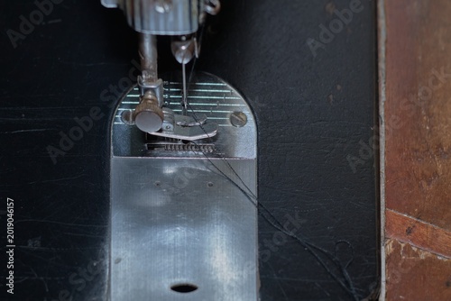 Foto Close-Up Of Vintage Sewing Machine Needle And Presser Foot With Black Thread On