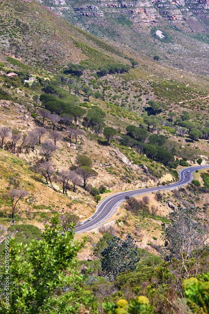 Naklejka premium Cars, mountain and road with landscape in nature for travel adventure, roadtrip and rocky terrain. Vehicles, hill and highway in natural environment for scenic route, getaway journey and vegetation