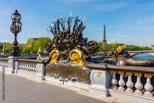 Tableau sur toile Sculptures on Alexander III bridge over Seine river with Eiffel tower at backgro