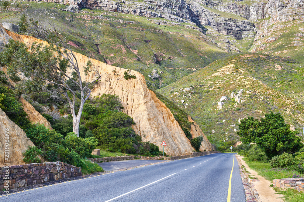 Naklejka premium Landscape, outdoor and road on mountain for travel, tourist destination and journey for adventure. Empty, background and street with scenic route, highway and nature for vacation, trip and holiday