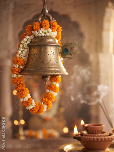 Janmashtami temple bell with marigold garland diya light and soft festive background