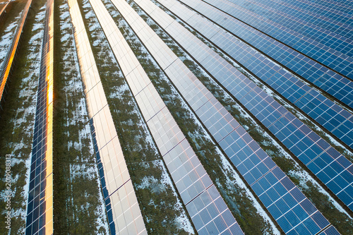 Fotografi Solar photovoltaic panels installed on a renewable energy farm absorb sunlight for electricity generation