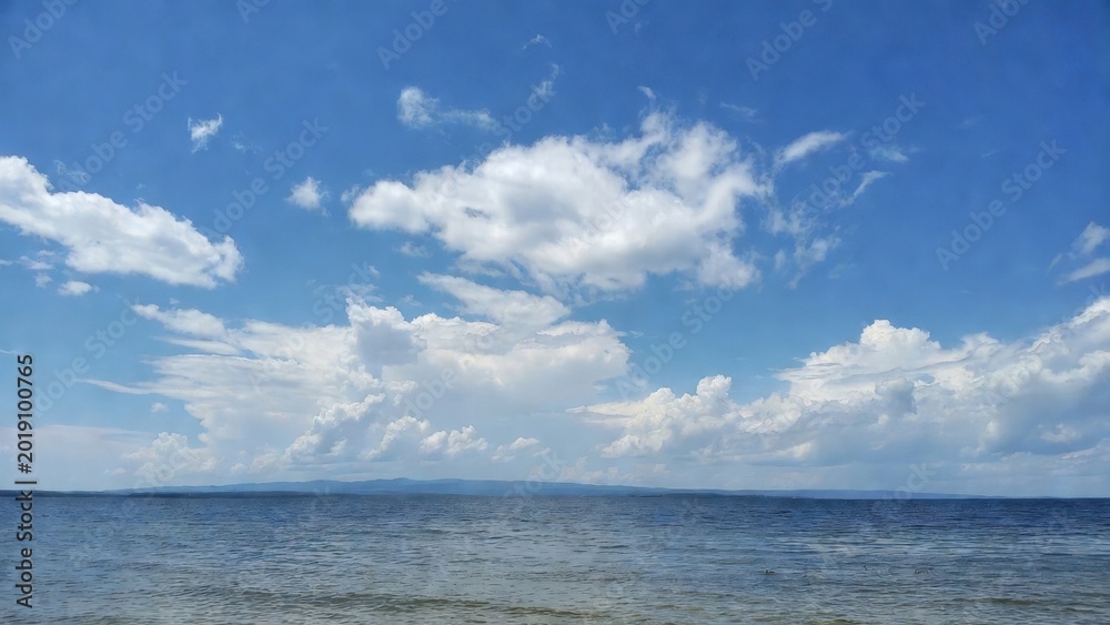 Fototapeta premium Open sea under scattered clouds at distant horizon