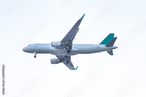 Narrow body passenger airplane flying at low altitude with landing gear deployed against a clean bright sky ideal for aviation and travel themes.