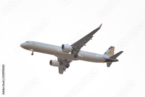 Wide body airliner with deployed landing gear flying beneath a pale evening sky captured from below for travel and aviation themes.
