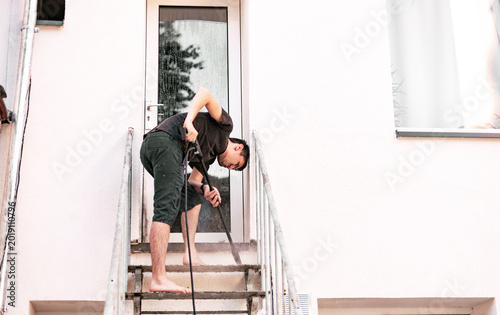 A man washes a garden staircase with a pressure washer in the yard.