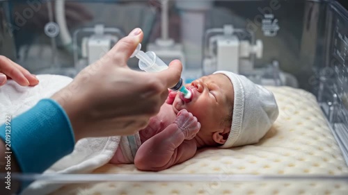 Newborn baby receiving care in neonatal intensive care unit.