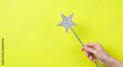 hand holding a glittery New Year star wand