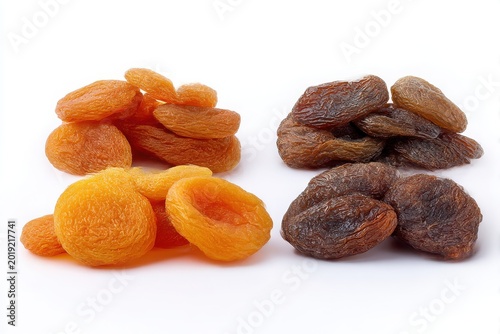 Four piles of dried apricots featuring two varieties orange and dark sweet fruity snacks white background