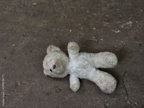 Cuadro en lienzo Abandoned dirty teddy bear plush toy lying on cold ground conveying sad lonely f