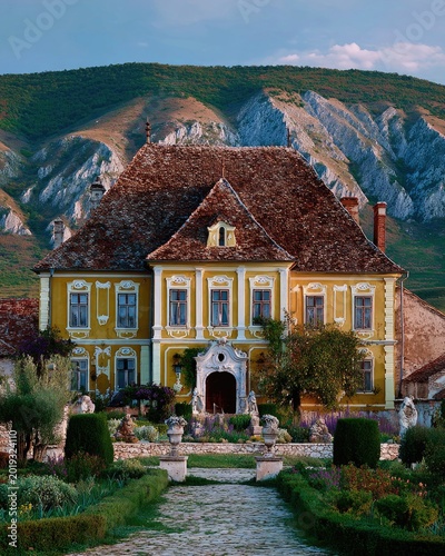 Yellow Baroque Mansion with Formal Garden and Mountain Backdrop