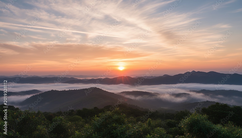 Naklejka premium Sunrise over misty mountains with fog in valley landscape