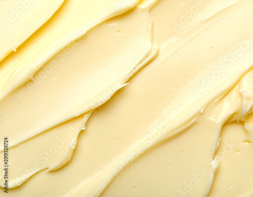 Smooth butter texture with creamy pale yellow folds and glossy highlights close up