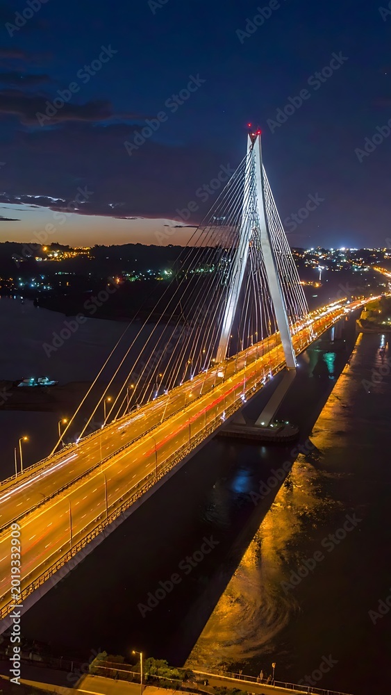Obraz premium A nighttime aerial view of a large suspension bridge over a body of water