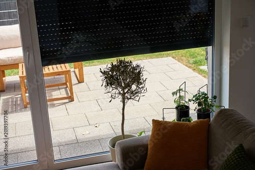 Partially lowered roller shutter over patio glass door