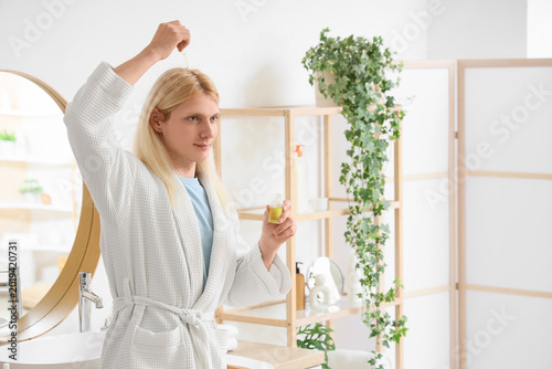Young blonde man applying h...